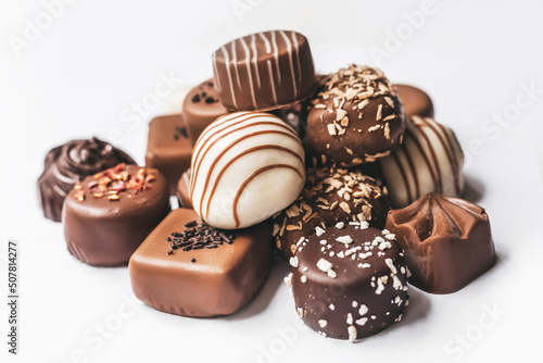 Assortment of dark, white and milk chocolate isolated on white background. Truffle, candy with decoration design. Various candy fillings. View from above