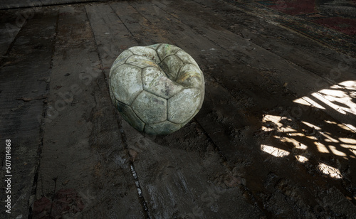 dirty loose wind soccer ball is on a muddy floor