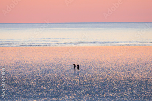 Fototapeta Naklejka Na Ścianę i Meble -  A couple are enjoying the beautiful sunset view at 80 mile beach, in Broome, Western Australia