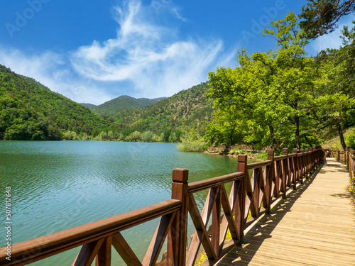 Wooden walkway by Lake Boraboy on a sunny spring day. © Ruhi
