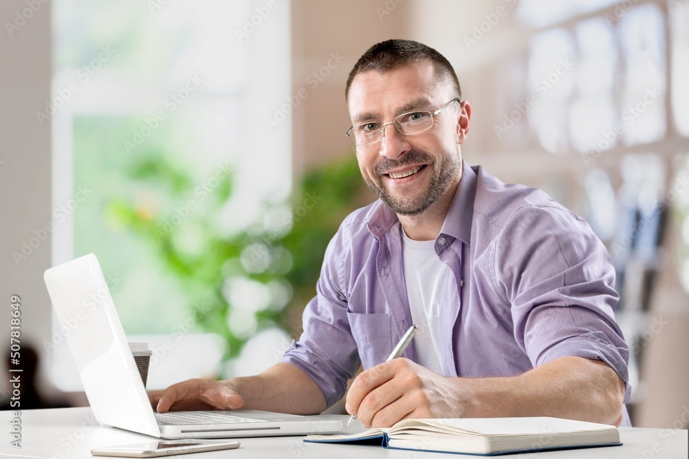 Busy Young Businessman Using Computer in Modern Office. Manager Thinks About Successful Financial Ideas. Busy Young Businessman Using Computer in Modern Office. Manager Thinks About Successful Financial Ideas.