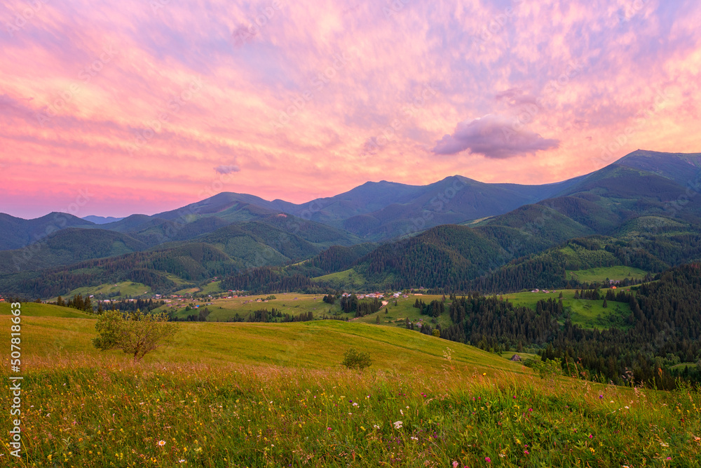 Amazing sunset mountain landscape. Scenic view of the summer alpine meadow, mountain range and colored sky with clouds, natural outdoor travel background, Carpathian Biosphere Reserve