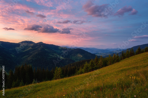 Amazing sunset mountain landscape. Scenic view of the summer alpine meadow, mountain range and colored sky with clouds, natural outdoor travel background, Carpathian Biosphere Reserve © larauhryn