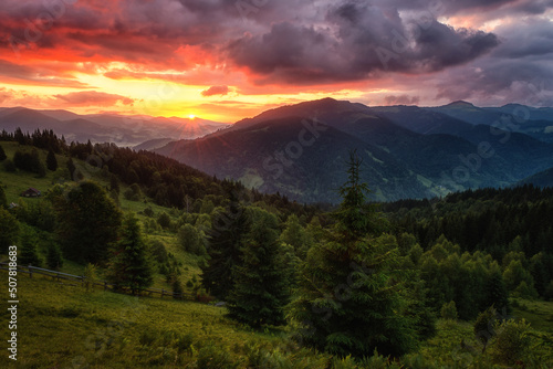 Amazing sunset mountain landscape. Fantastic view of the green summer hill and colored sky with clouds, natural outdoor travel background, Carpathian Biosphere Reserve © larauhryn