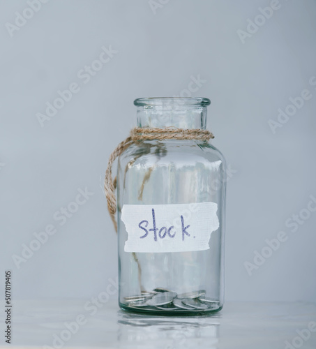Glass jar with coins placed on white background isolated concept for saving money to keep in reserve for emergency expenses.