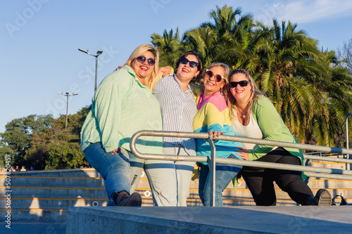 group of friends latin female plus size models with sunglasses outdoors posing looking at the camera © SETO fotografias