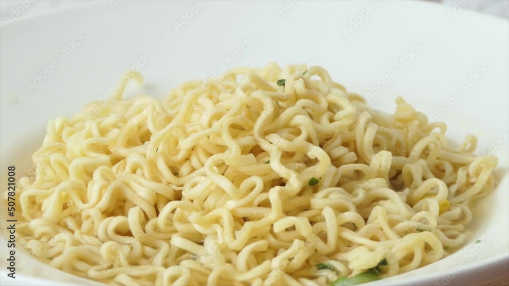 Fast food pasta close-up. Instant noodles in a soup bowl with Chinese chopsticks. Fast food pasta close-up. Instant noodles in a soup bowl with Chinese chopsticks.