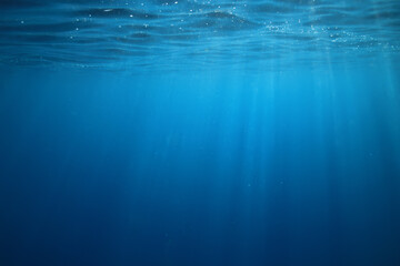 ocean underwater rays of light background, under blue water sunlight
