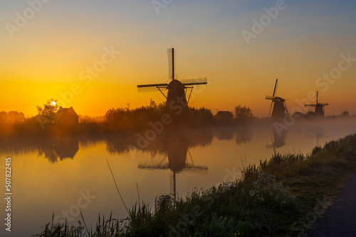 Traditional Dutch windmills with a colourful sky just before sunrise in Kinderdijk, The Netherlands