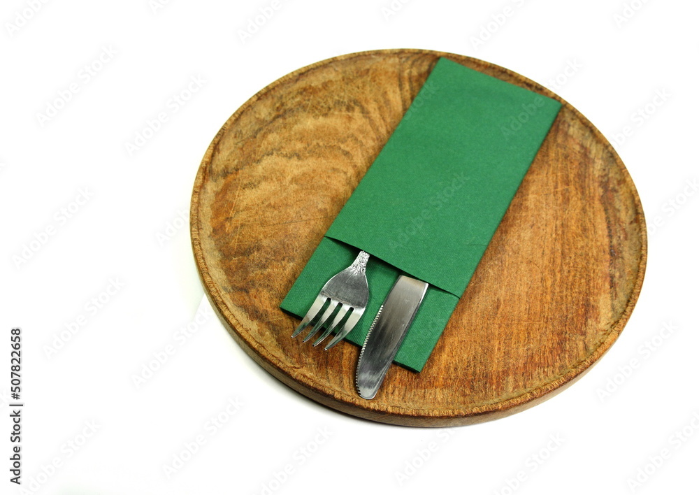 knife and fork at napkin on old rustic wooden board isolated on white background knife and fork at napkin on old rustic wooden board isolated on white background