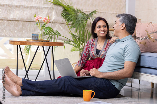 Canvas Print Beautiful couple using laptop while working on home budget