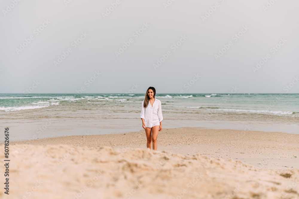 Happy woman standing on sandy beach Happy woman standing on sandy beach