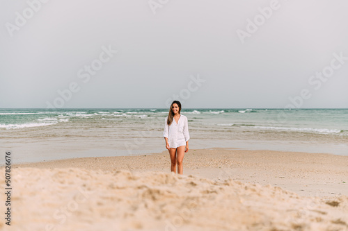 Happy woman standing on sandy beach