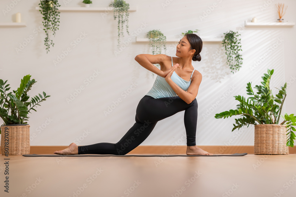 Calm of Asian woman in sportwear stretching muslce to warm up breathing and meditation with yoga at home.Healthy female doing yoga Feeling so comfortable and relax,Wellness Yoga Healthcare Concept Calm of Asian woman in sportwear stretching muslce to warm up breathing and meditation with yoga at home.Healthy female doing yoga Feeling so comfortable and relax,Wellness Yoga Healthcare Concept