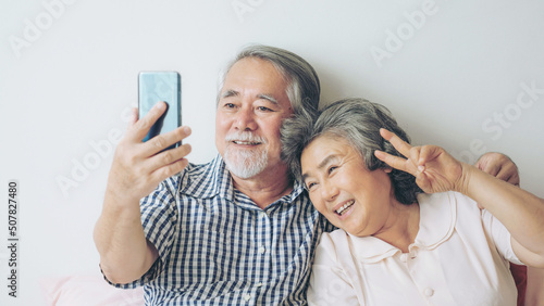 Fotografia Senior couple using a smart phone computer face time call to relatives descendan