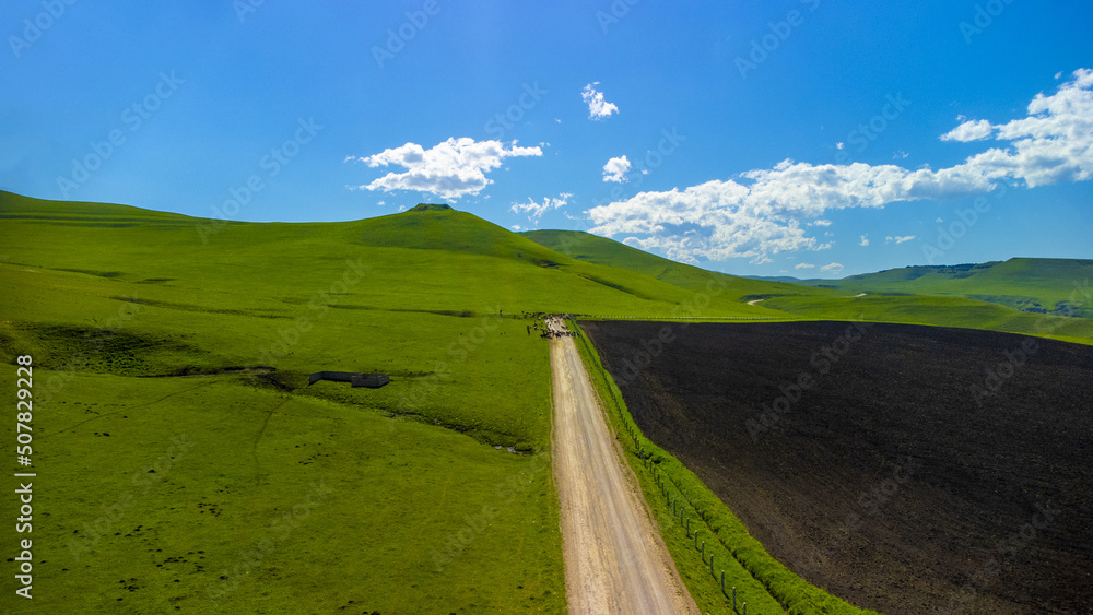 Top view from a drone on mountain pastures and road Top view from a drone on mountain pastures and road