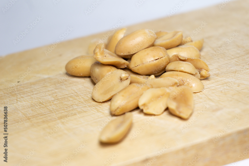 Salted peanuts peeled separately on a wooden table. Salted peanuts peeled separately on a wooden table.