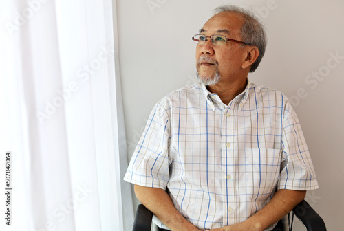 Unhappiness Asia man alone on wheelchair at home.