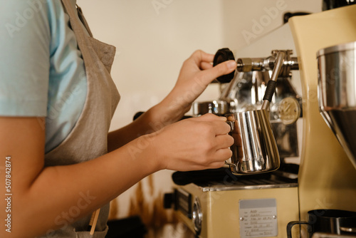Young asian barista woman making coffee in cafe