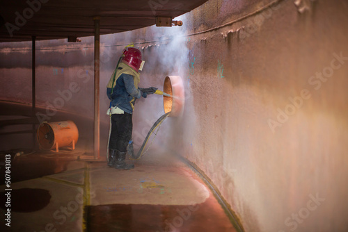 Fotografia, Obraz Male worker surface corrosion plate preparation by sand blasting of tank interna