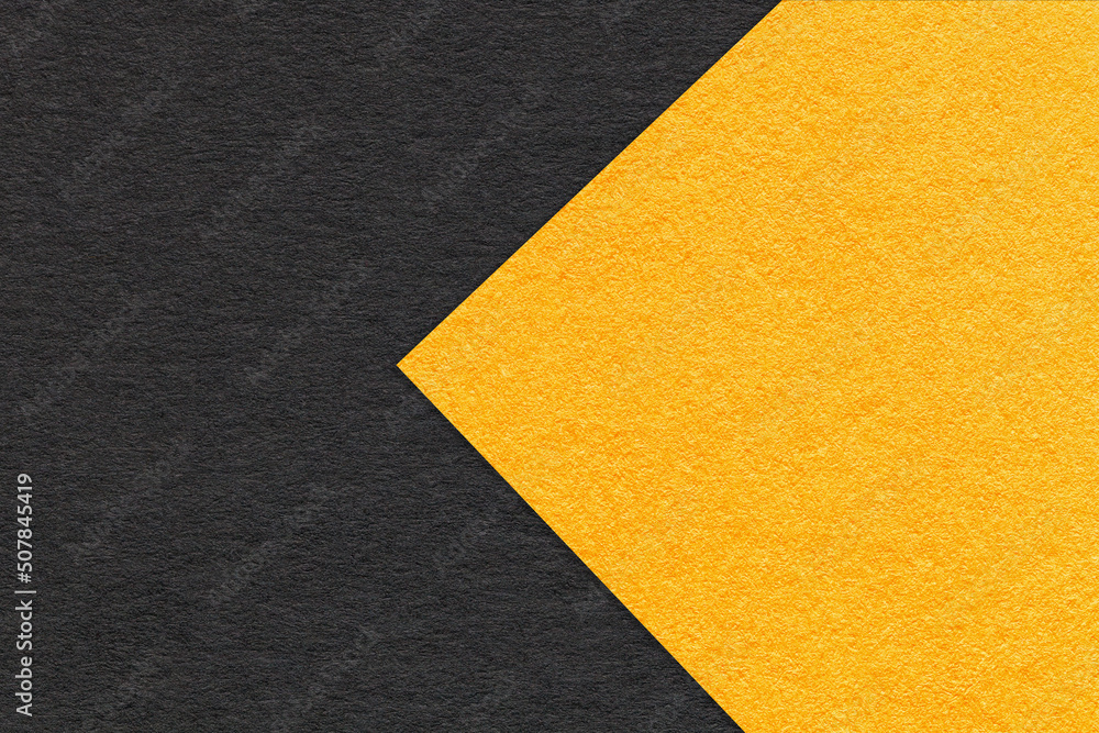 Texture of black and yellow paper background, half two colors, macro. Structure of dense craft cardboard. Texture of black and yellow paper background, half two colors, macro. Structure of dense craft cardboard.