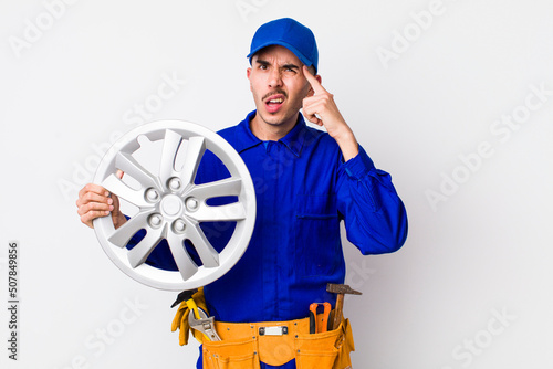 hispanic man feeling confused and puzzled, showing you are insane. car mechanic concept