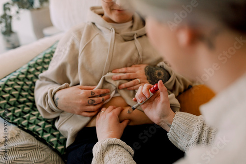 Lesbian women doing IVF test with syringe at home photo