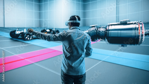 Automotive Engineer Using a VR Software to Showcase Electric Motor and Vehicle Platform in Interactive Environment. Multiethnic Engineer Using Virtual Reality Headset and Controllers for His Project.