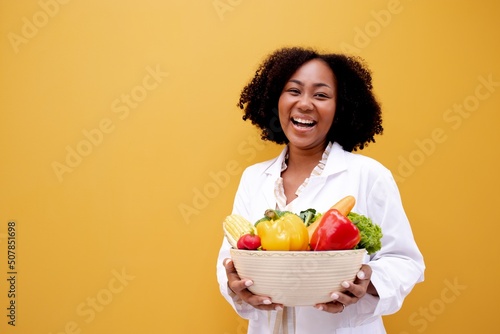 Portrait African American Positive dietitian with fruits and vegetables for healthy eating and diet. Healthy food, dietitian consultation.Brazilian Nutritionist consultant health care Isolated. photo