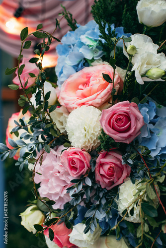 Bouquets of blue  white  pink and red flowers adorn the wedding venue at the entrance to the restaurant.