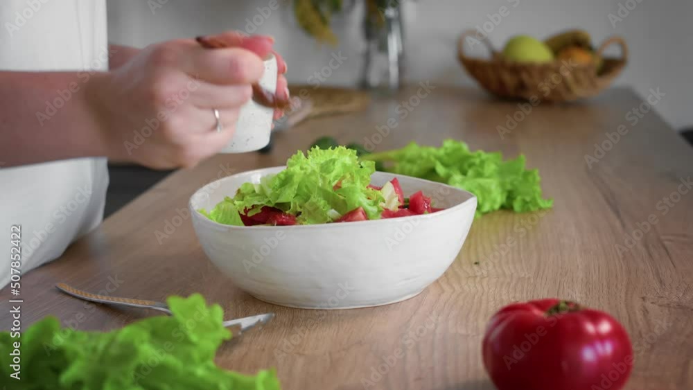 Close-up of an unrecognizable woman's hand preparing a salad. Cooking in the kitchen. Close-up of an unrecognizable woman's hand preparing a salad. Cooking in the kitchen.