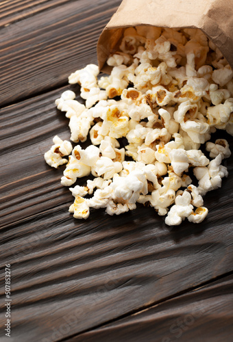 Obraz na płótnie Popped corn snack in paper bag on wooden table closeup w salonie