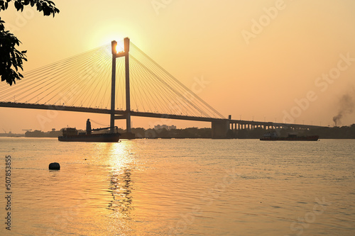 Beautiful famous Kolkata Hoogly bridge in sunset . light reflection on Ganges top sights. Travel tourism in Kolkata. © Subhankar