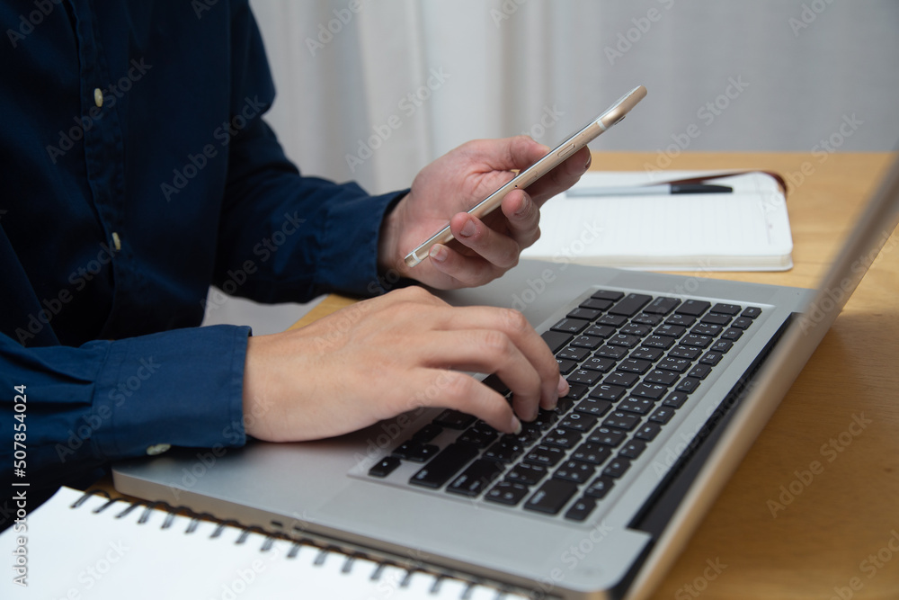 Close up Business man using laptop for do math finance on wooden desk, tax, accounting, statistics and analytical research concept Close up Business man using laptop for do math finance on wooden desk, tax, accounting, statistics and analytical research concept