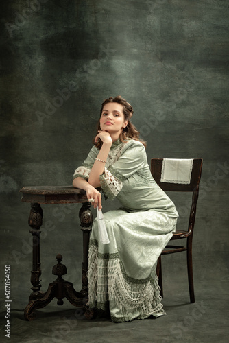 Obraz na plátně Vintage portrait of young beautiful girl in gray dress of medieval style isolated on dark background