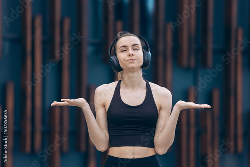 Girl with earphones standing disappointed  annoyed.