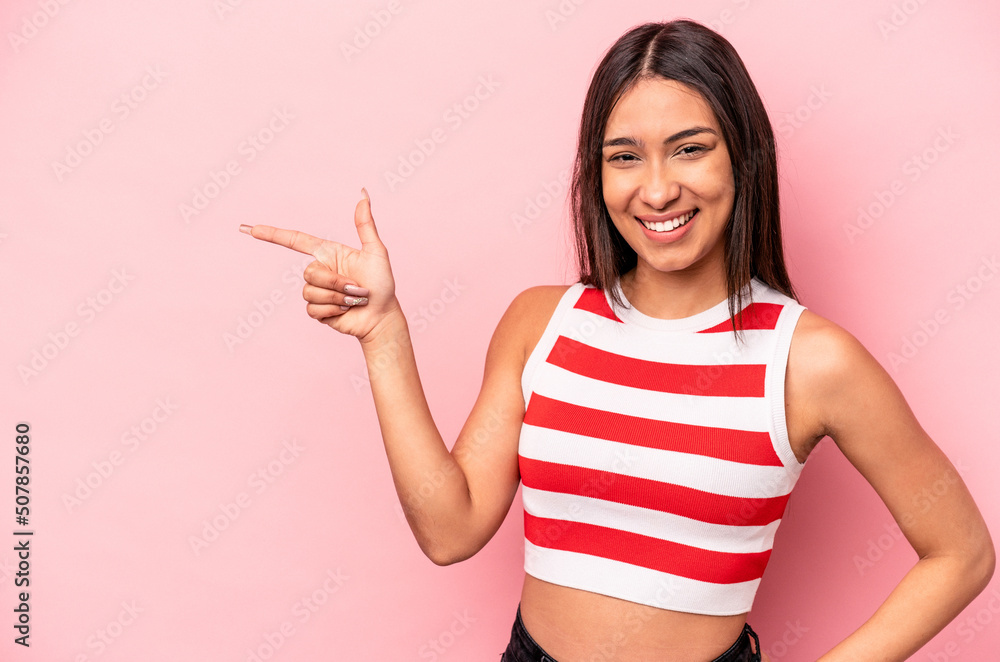 Young hispanic woman isolated on pink background smiling cheerfully pointing with forefinger away. Young hispanic woman isolated on pink background smiling cheerfully pointing with forefinger away.