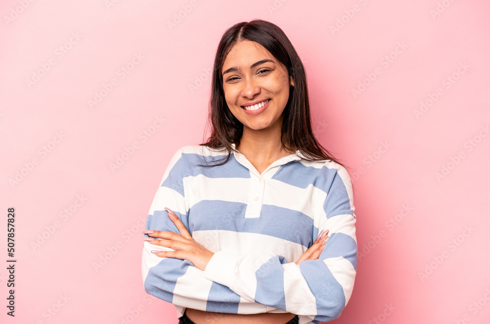 Young hispanic woman isolated on pink background who feels confident, crossing arms with determination. Young hispanic woman isolated on pink background who feels confident, crossing arms with determination.