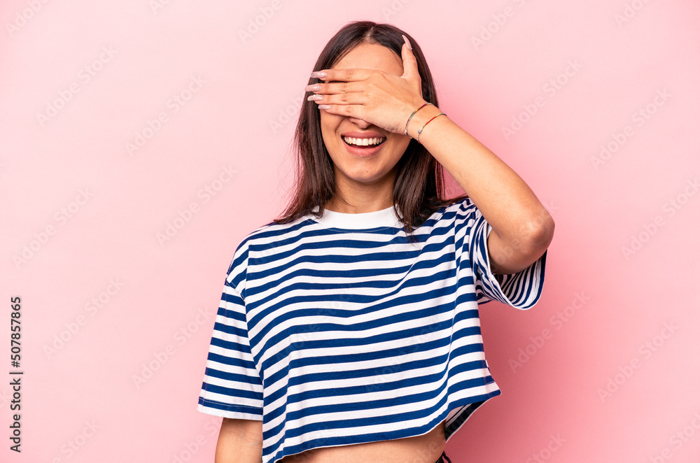 Young hispanic woman isolated on pink background covers eyes with hands, smiles broadly waiting for a surprise. Young hispanic woman isolated on pink background covers eyes with hands, smiles broadly waiting for a surprise.