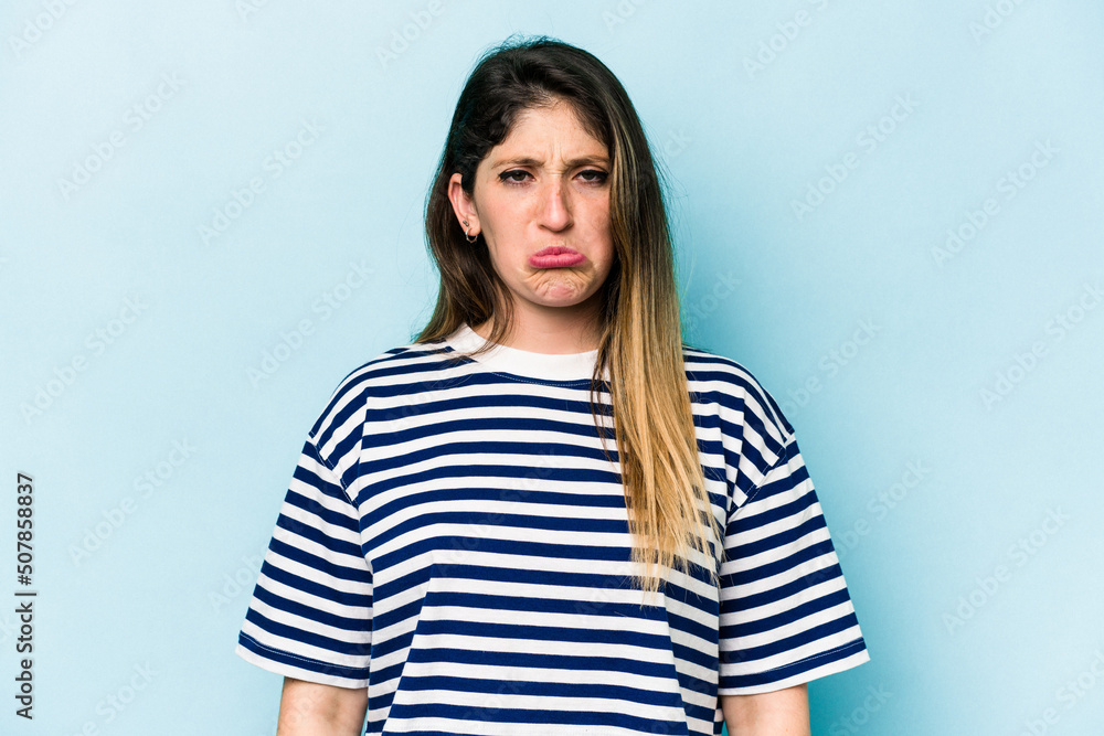 Young caucasian woman isolated on blue background sad, serious face, feeling miserable and displeased. Young caucasian woman isolated on blue background sad, serious face, feeling miserable and displeased.