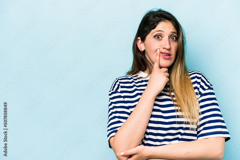 Young caucasian woman isolated on blue background looking sideways with doubtful and skeptical expression. Young caucasian woman isolated on blue background looking sideways with doubtful and skeptical expression.