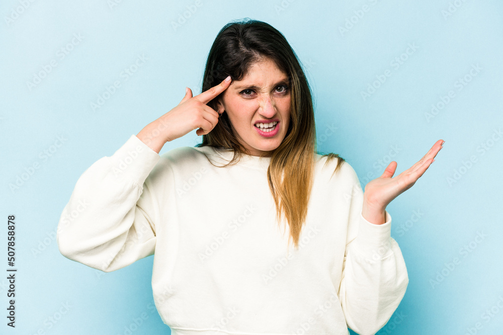 Young caucasian woman isolated on blue background showing a disappointment gesture with forefinger. Young caucasian woman isolated on blue background showing a disappointment gesture with forefinger.
