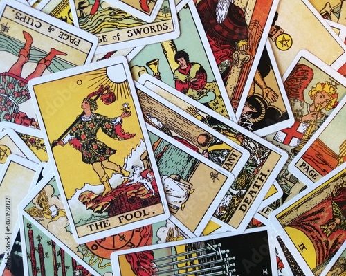 Picture of The Fool tarot card from the original Ride Waite tarot deck with mixed tarot cards in the background
