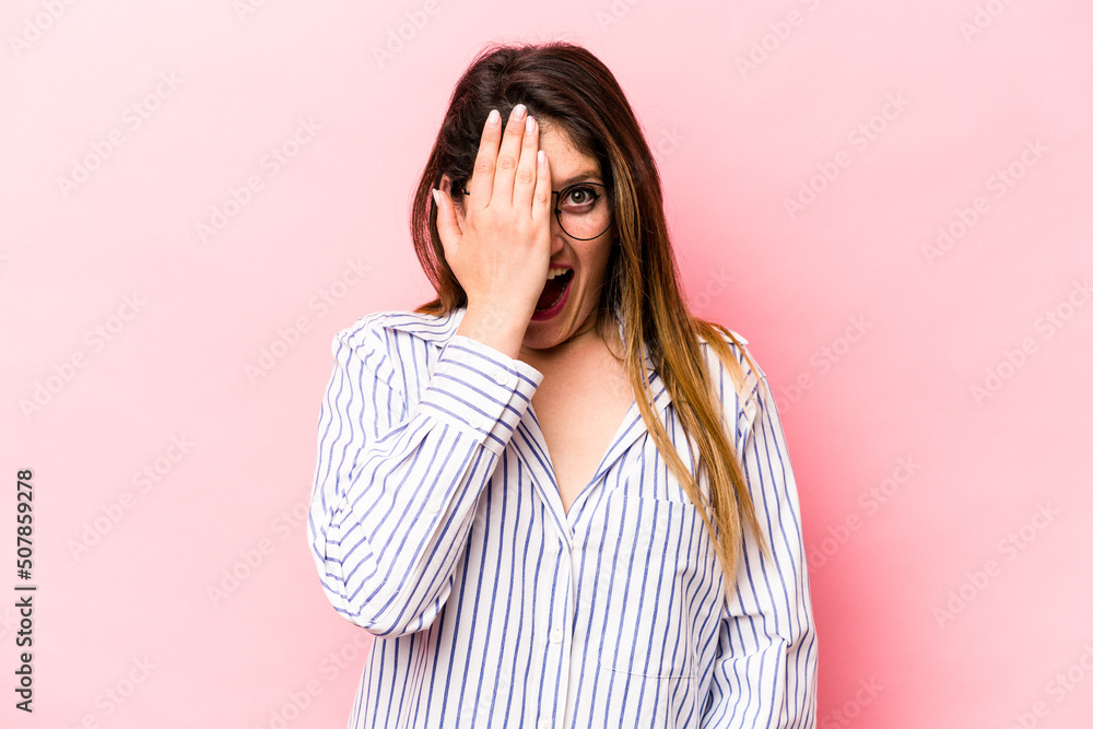 Young caucasian woman isolated on pink background having fun covering half of face with palm. Young caucasian woman isolated on pink background having fun covering half of face with palm.
