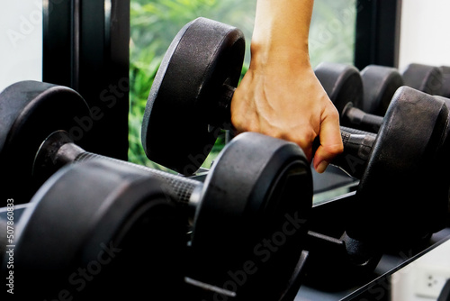 Close up of hand holding dumbbell in fitness.