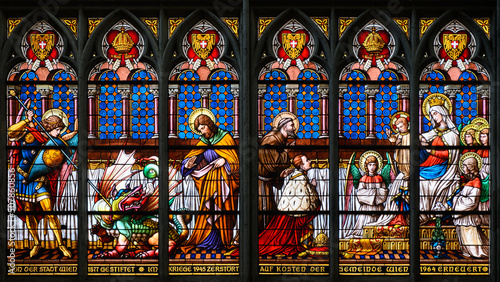 Stained-glass window: young emperor Franz Joseph kneeling in front of the Virgin Mary and Jesus. Votivkirche – Votive Church, Vienna, Austria. 2020-07-29.  photo