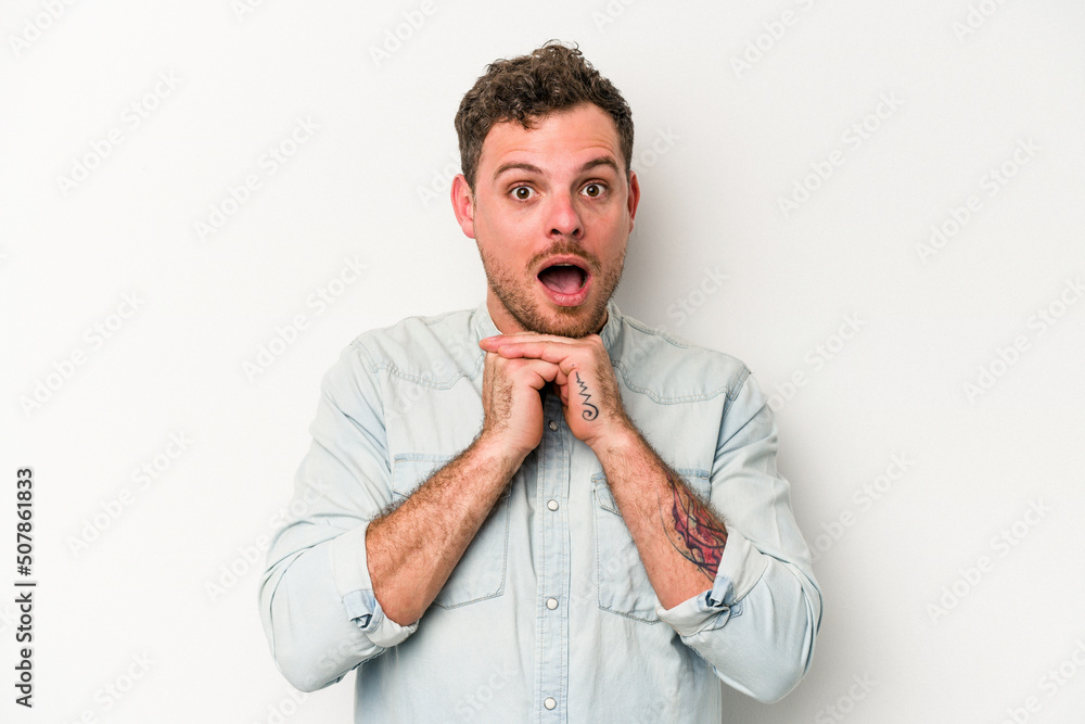 Young caucasian man isolated on white background praying for luck, amazed and opening mouth looking to front. Young caucasian man isolated on white background praying for luck, amazed and opening mouth looking to front.