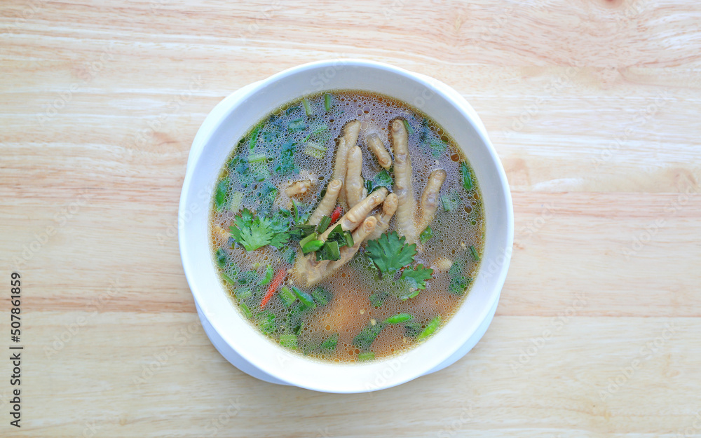 Chicken Foot with hot and sour soup in bowl on wood table background. Thai food. Top view. Chicken Foot with hot and sour soup in bowl on wood table background. Thai food. Top view.
