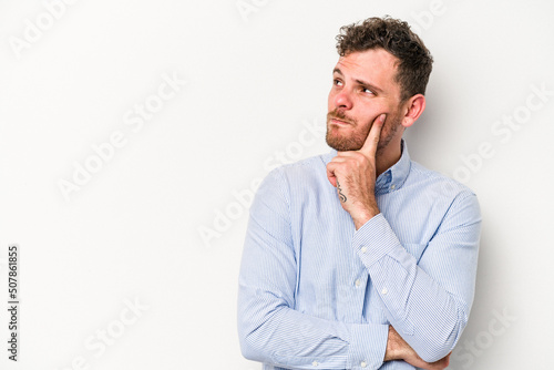 Young caucasian man isolated on white background looking sideways with doubtful and skeptical expression. © Asier