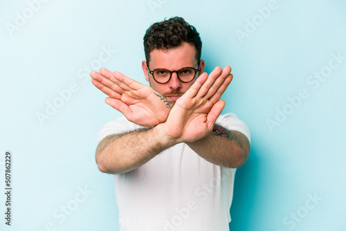 Φωτογραφία Young caucasian man isolated on blue background doing a denial gesture